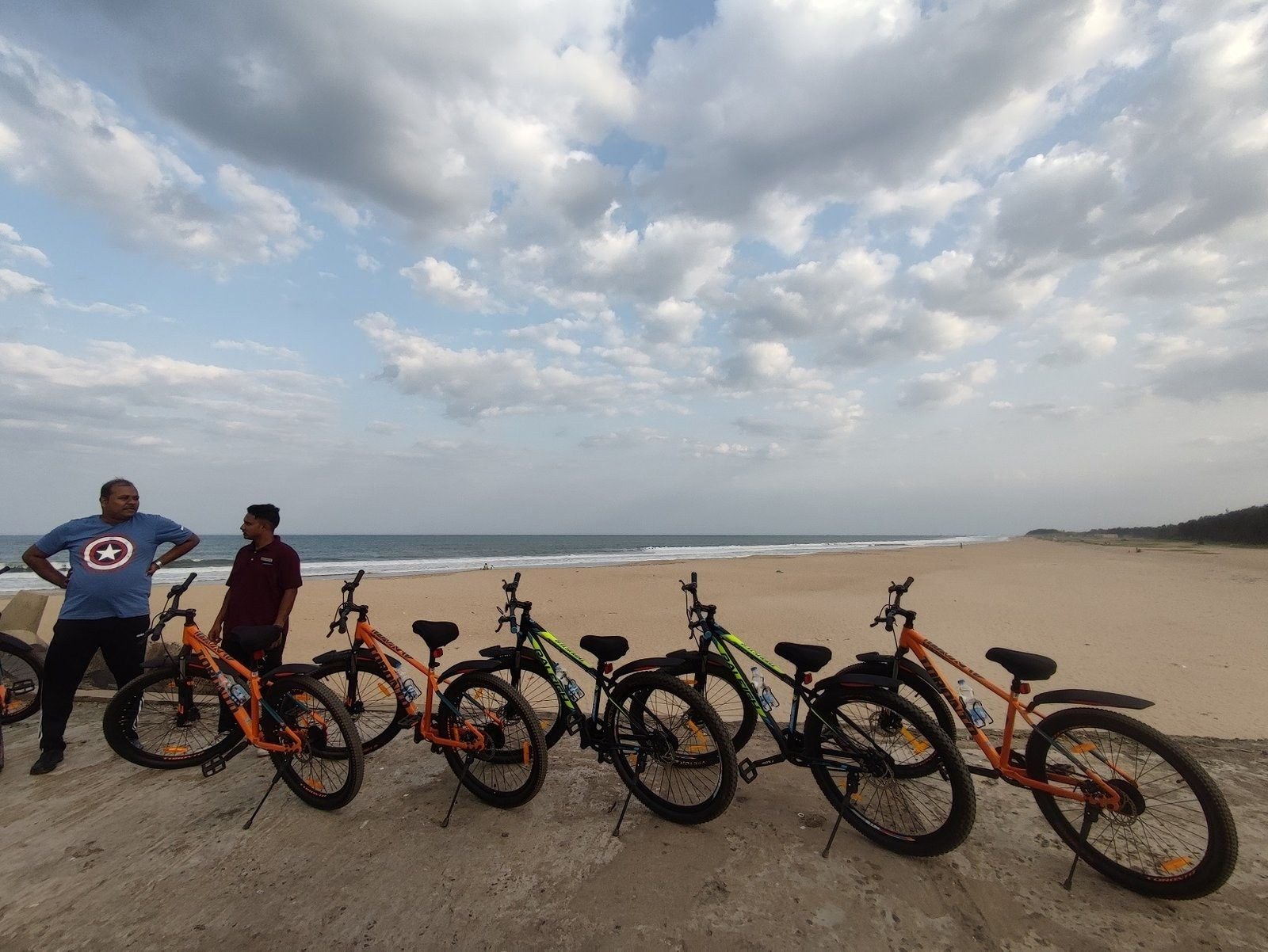 Bicycles lined up on a quiet Pondicherry beach on a cycling tour