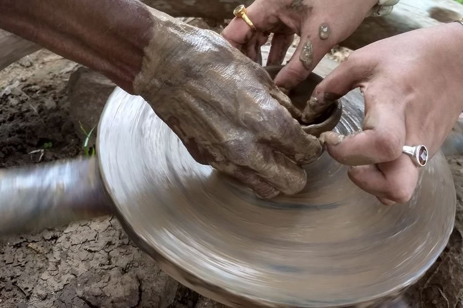 Hands shaping clay on a potter’s wheel in a village near Pondicherry