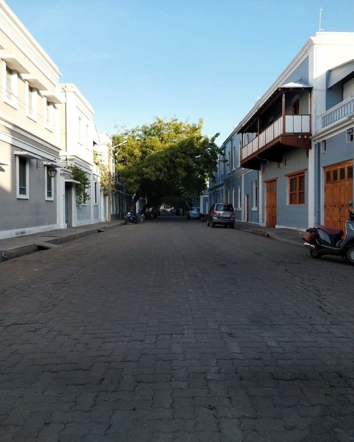 A quiet cobbled street in Pondicherry's French quarter lined with colonial houses and wooden balconies