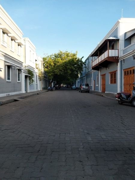 A quiet cobbled street in Pondicherry's French quarter lined with colonial houses and wooden balconies